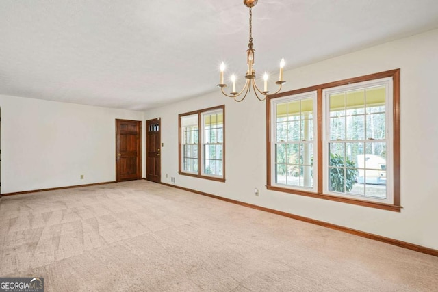 carpeted spare room featuring a notable chandelier