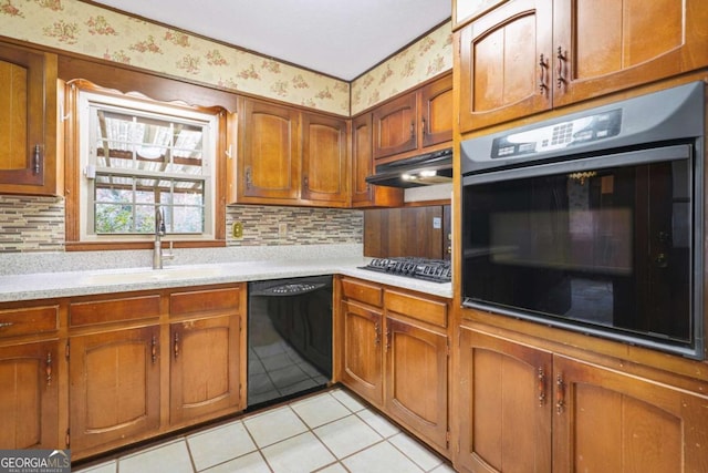 kitchen featuring backsplash, sink, light tile patterned floors, and black appliances