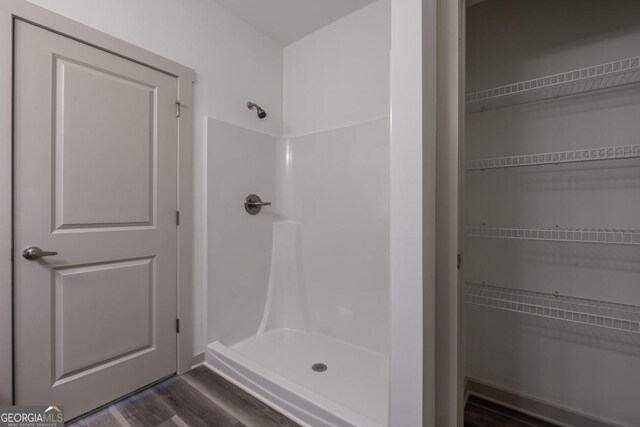 bathroom with hardwood / wood-style floors and walk in shower