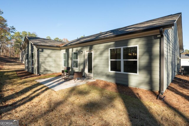 back of property featuring a yard and a patio