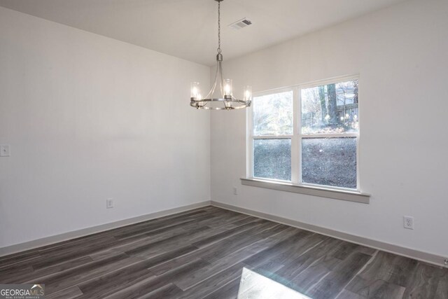 unfurnished room featuring dark wood-type flooring and a chandelier