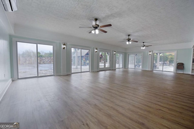 unfurnished living room featuring hardwood / wood-style floors, ceiling fan, and a healthy amount of sunlight