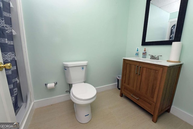 bathroom featuring vanity, toilet, and curtained shower