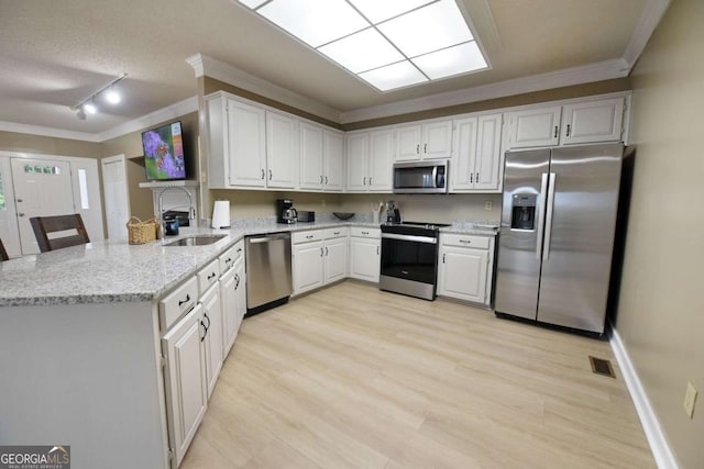 kitchen featuring white cabinets, sink, light stone countertops, kitchen peninsula, and stainless steel appliances