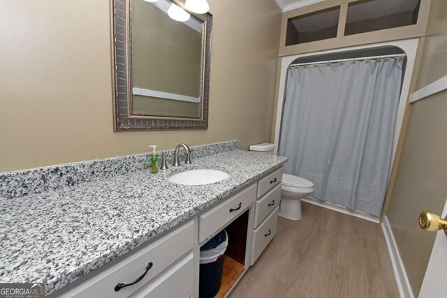 bathroom with a shower with curtain, hardwood / wood-style floors, vanity, and toilet