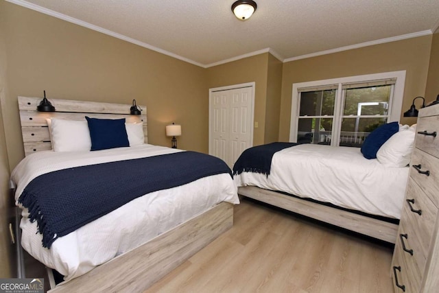 bedroom featuring a closet, light hardwood / wood-style floors, a textured ceiling, and ornamental molding