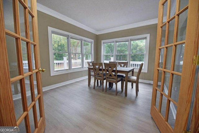 dining room with french doors, light hardwood / wood-style flooring, and ornamental molding