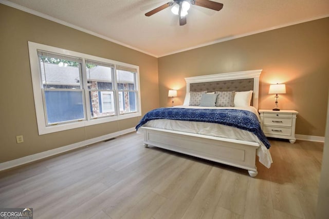 bedroom with a textured ceiling, ceiling fan, light hardwood / wood-style floors, and crown molding