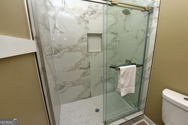 bathroom with an enclosed shower and toilet