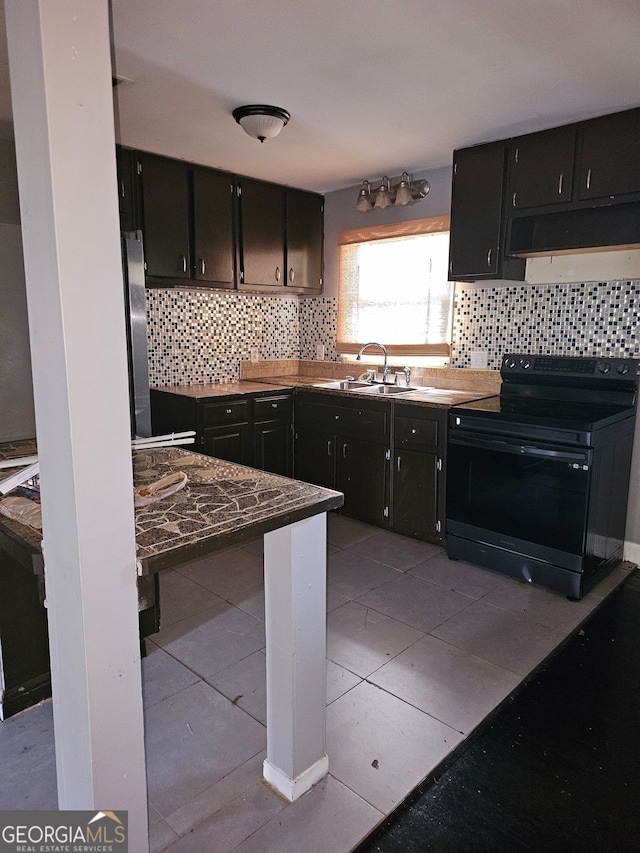 kitchen featuring tasteful backsplash, sink, light tile patterned flooring, black / electric stove, and stainless steel fridge