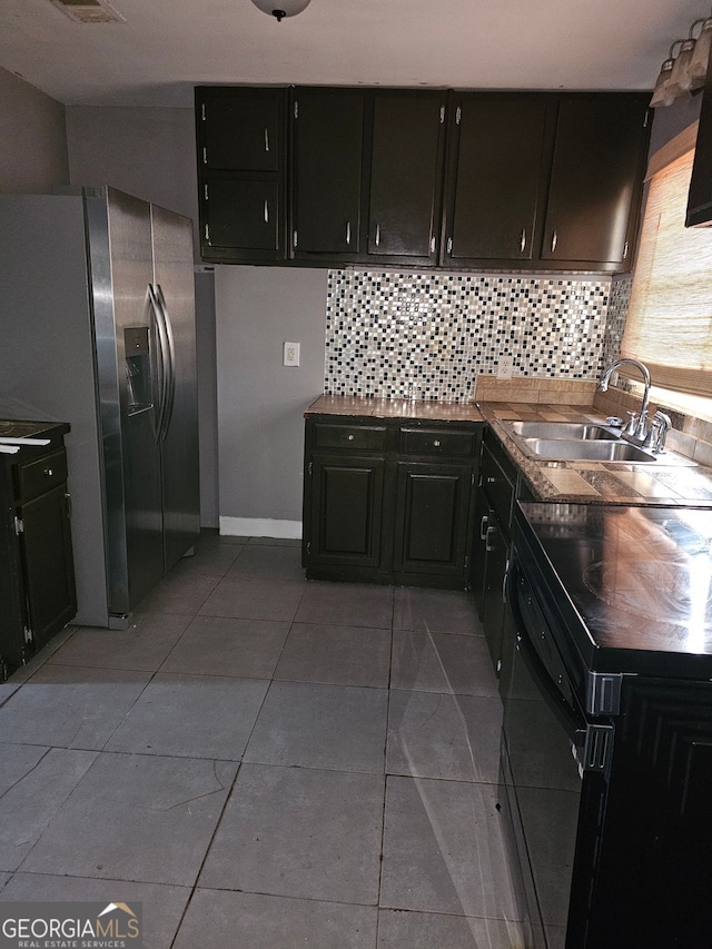 kitchen with black range with electric cooktop, stainless steel fridge, sink, and light tile patterned flooring