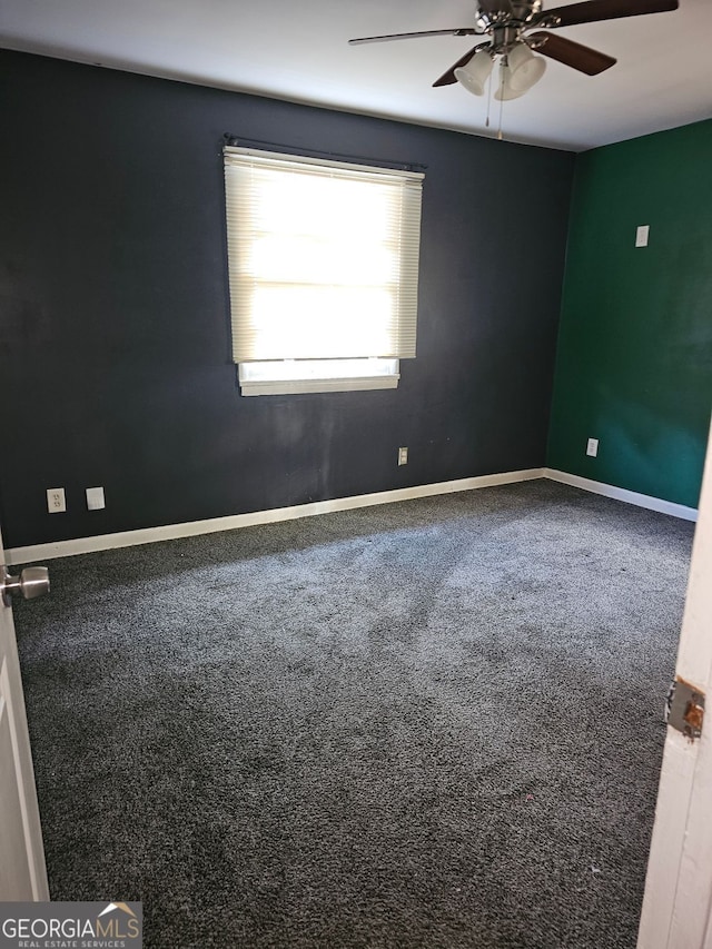 empty room featuring ceiling fan and carpet