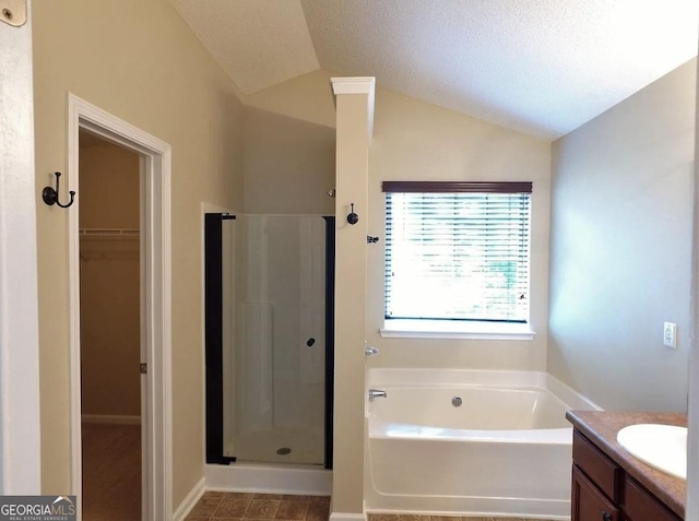 bathroom with plus walk in shower, vanity, a textured ceiling, and lofted ceiling