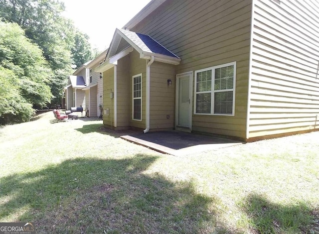 back of property featuring a lawn and a patio