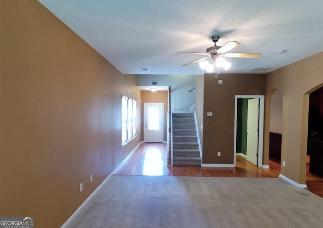 carpeted spare room featuring ceiling fan