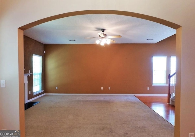 carpeted spare room with a textured ceiling and ceiling fan