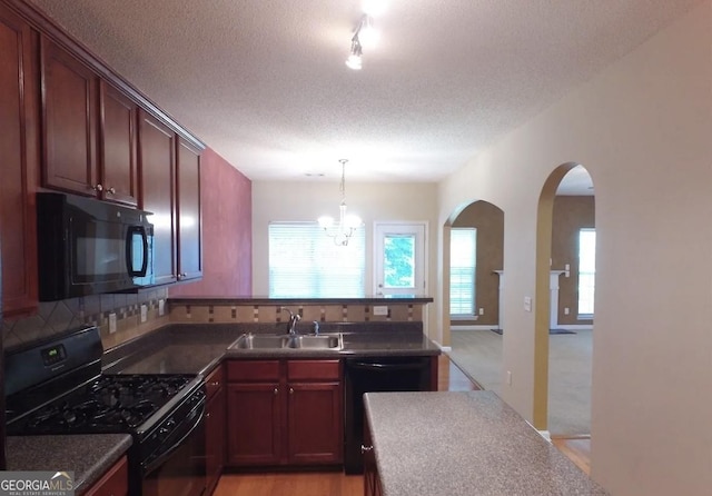 kitchen with a textured ceiling, sink, black appliances, a chandelier, and hanging light fixtures