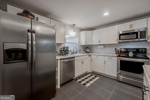 kitchen with white cabinets, stainless steel appliances, hanging light fixtures, and sink