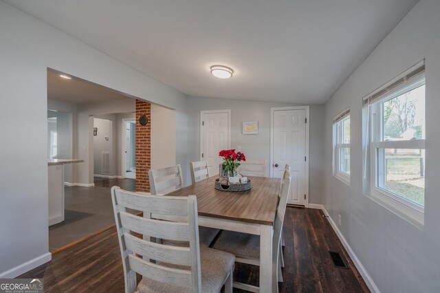 dining area featuring dark hardwood / wood-style flooring and vaulted ceiling