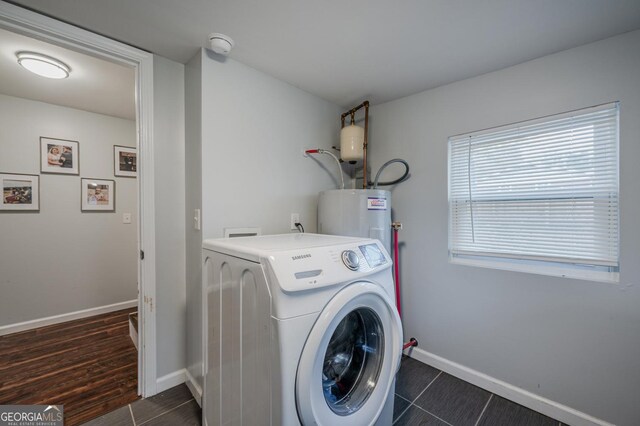 washroom featuring water heater, dark wood-type flooring, and washer / dryer