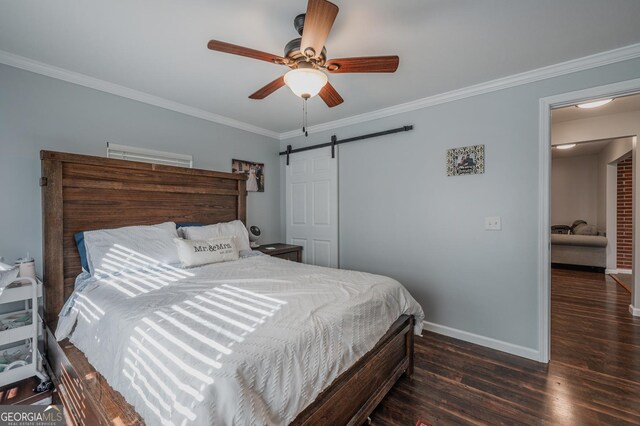 bedroom with a barn door, ceiling fan, dark hardwood / wood-style floors, and ornamental molding