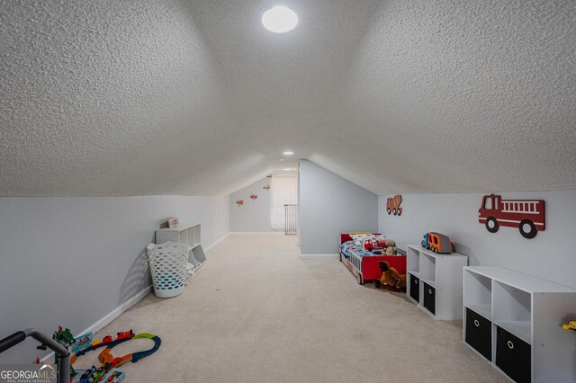 playroom with a textured ceiling, carpet, and lofted ceiling