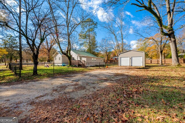 view of yard featuring a garage and an outbuilding