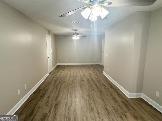 empty room featuring ceiling fan and dark hardwood / wood-style flooring