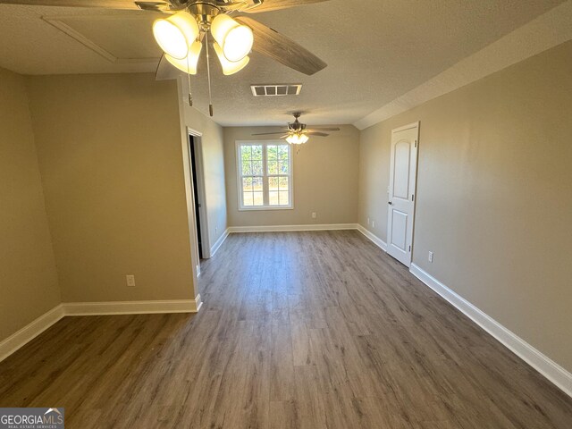 spare room with hardwood / wood-style floors, ceiling fan, and a textured ceiling