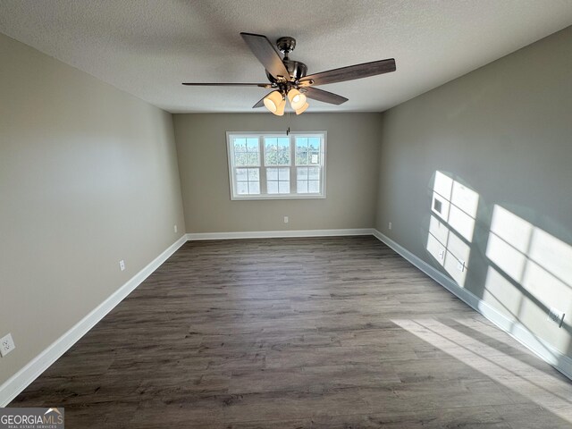 empty room with dark hardwood / wood-style floors, ceiling fan, and a textured ceiling