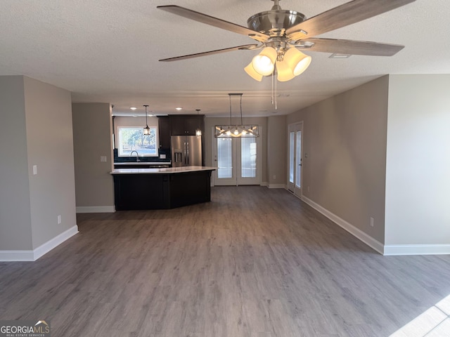 kitchen featuring stainless steel refrigerator with ice dispenser, a textured ceiling, ceiling fan, dark wood-type flooring, and sink