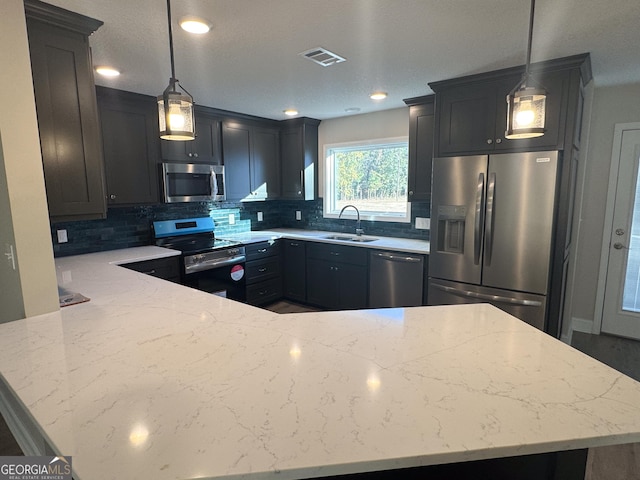 429 Deens Landing Rd, Baxley, GA 31513 - kitchen with appliances with stainless steel finishes, a sink, backsplash, light stone countertops, and a peninsula