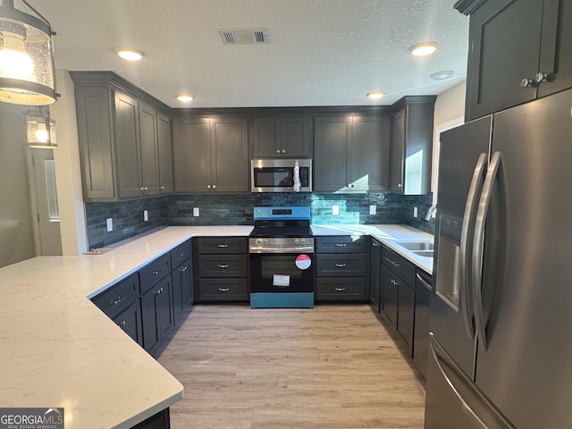 429 Deens Landing Rd, Baxley, GA 31513 - kitchen with appliances with stainless steel finishes, a sink, light wood-style flooring, backsplash, and a textured ceiling