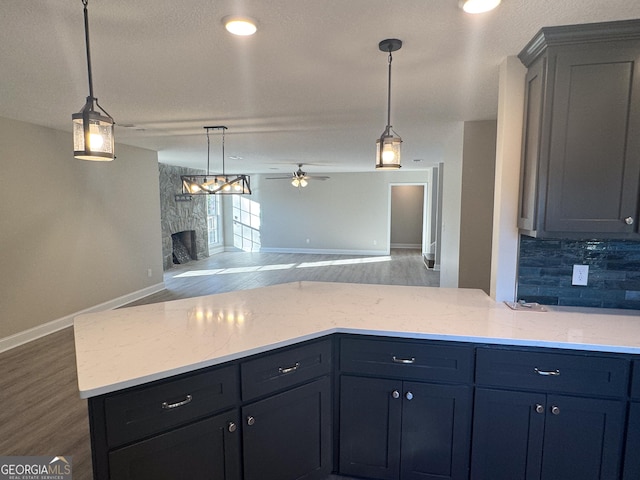429 Deens Landing Rd, Baxley, GA 31513 - kitchen with a fireplace, wood finished floors, a ceiling fan, and decorative backsplash