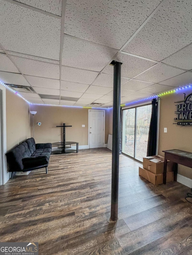 basement with a drop ceiling and wood-type flooring