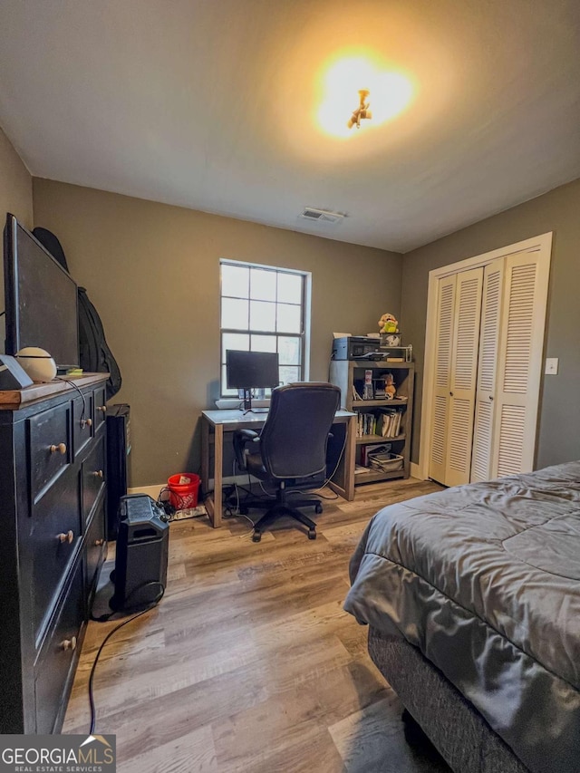 bedroom featuring hardwood / wood-style floors and a closet