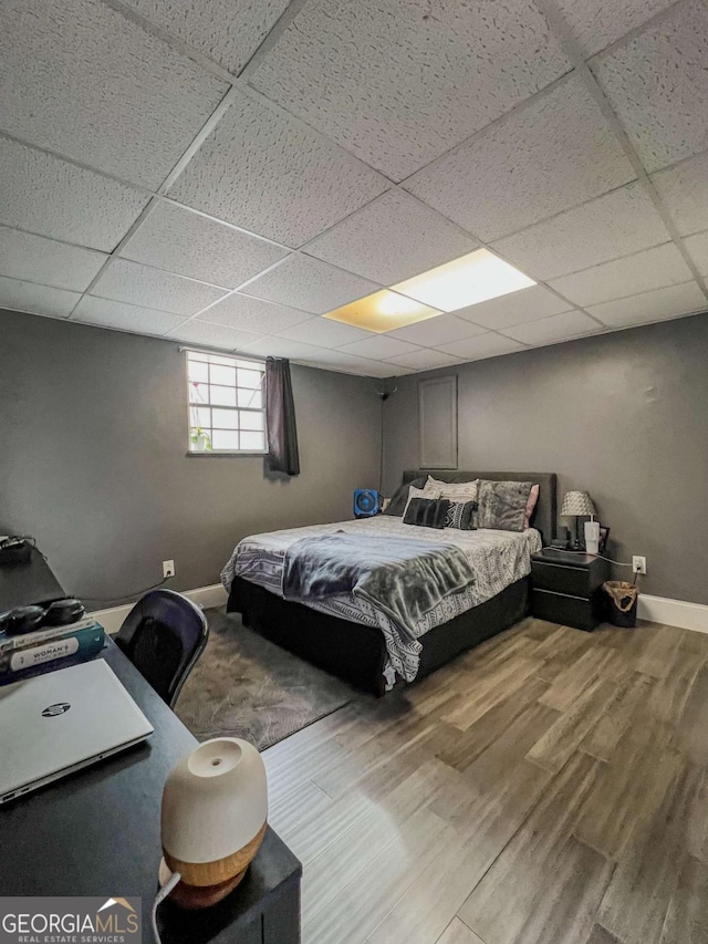 bedroom featuring hardwood / wood-style floors and a drop ceiling