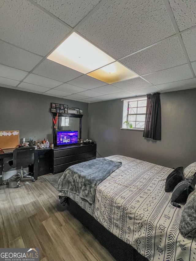 bedroom featuring hardwood / wood-style floors and a paneled ceiling