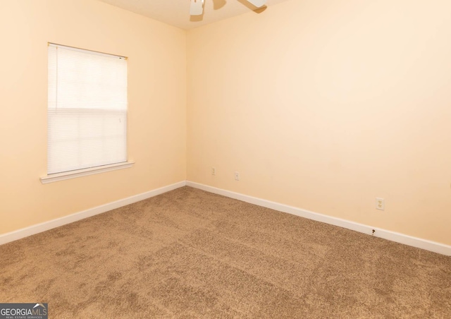 carpeted spare room with ceiling fan