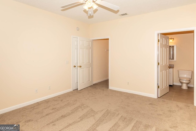 unfurnished bedroom with connected bathroom, ceiling fan, and light colored carpet