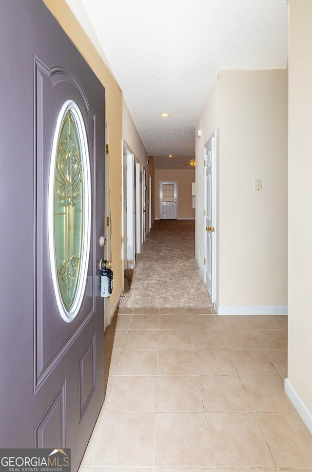 foyer featuring light carpet and ceiling fan