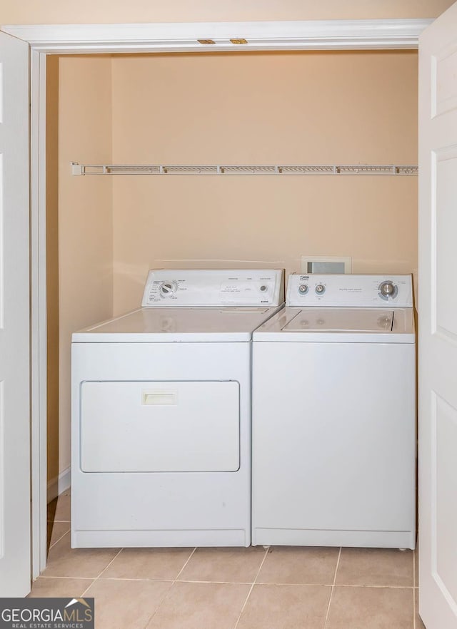 laundry room with washing machine and dryer and light tile patterned floors