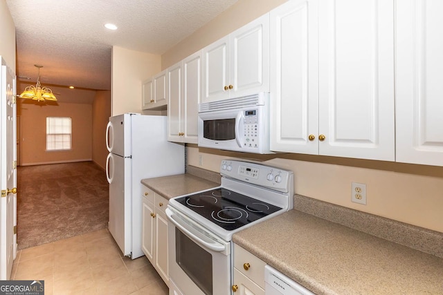 kitchen with light carpet, a textured ceiling, white appliances, white cabinetry, and hanging light fixtures