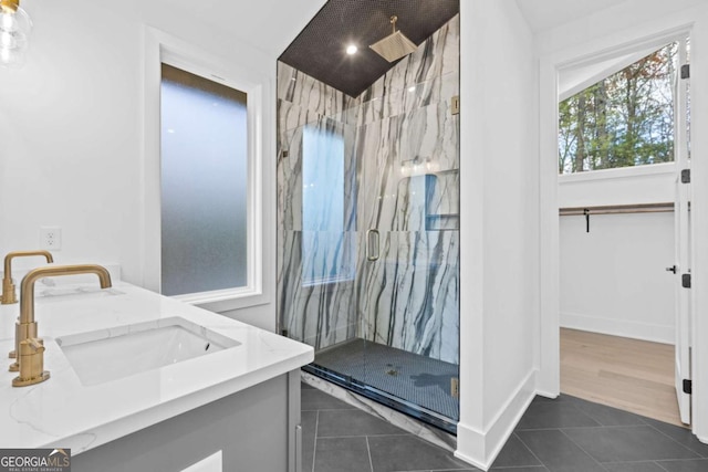 bathroom with walk in shower, vanity, and tile patterned flooring