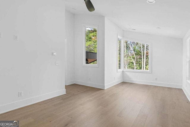 spare room featuring ceiling fan, lofted ceiling, and light hardwood / wood-style floors