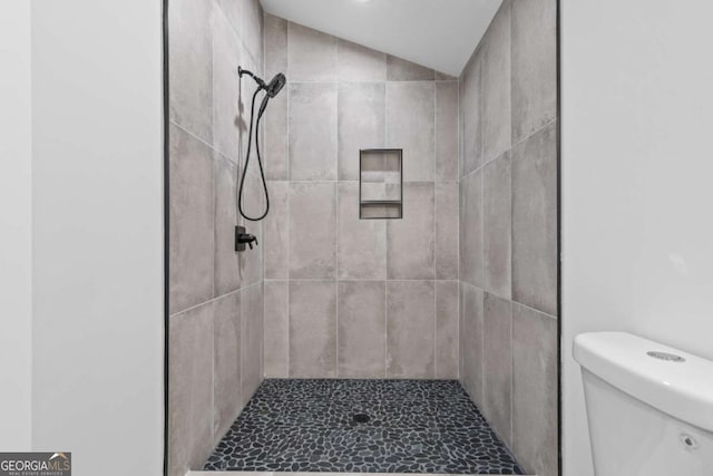 bathroom featuring toilet and tiled shower