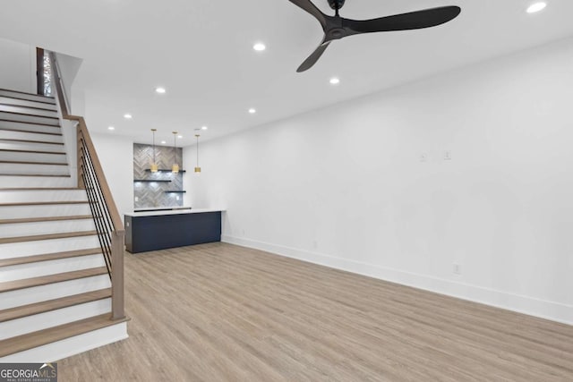 unfurnished living room with ceiling fan and wood-type flooring