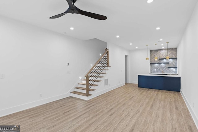 unfurnished living room featuring ceiling fan and light wood-type flooring