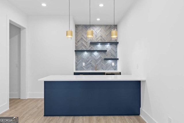 kitchen featuring hanging light fixtures, light hardwood / wood-style flooring, and kitchen peninsula