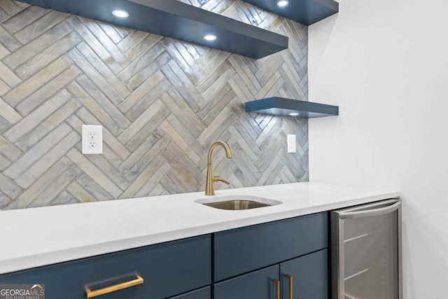 kitchen featuring tasteful backsplash, sink, and blue cabinetry